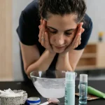 Persona che si sta lavando il viso con l'acqua