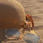 cappello e occhiali sulla sabbia