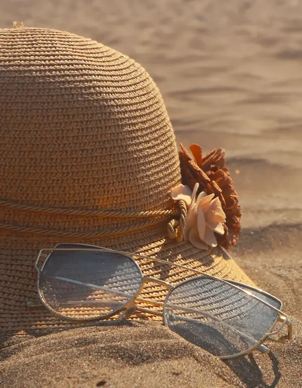 cappello e occhiali sulla sabbia