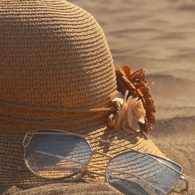 cappello e occhiali sulla sabbia